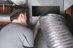 A ventilation cleaner man at work with tool